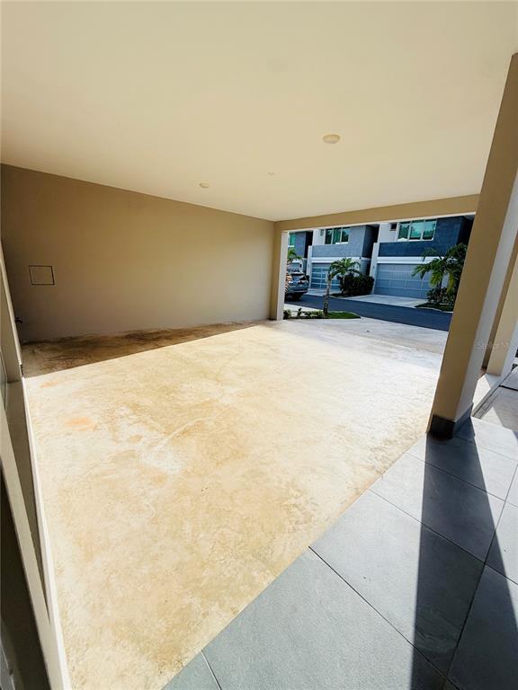 A covered concrete carport area with a view of a neighboring residential street — Urb Riviera Court 57, BAYAMON, PR