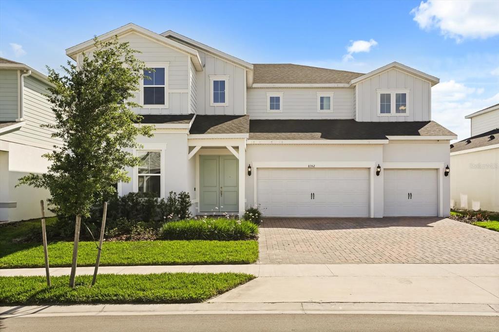 A two-story house with light-colored siding, a three-car garage, and a paved driveway — 8352 PARK CLIFF WAY, ORLANDO, FL