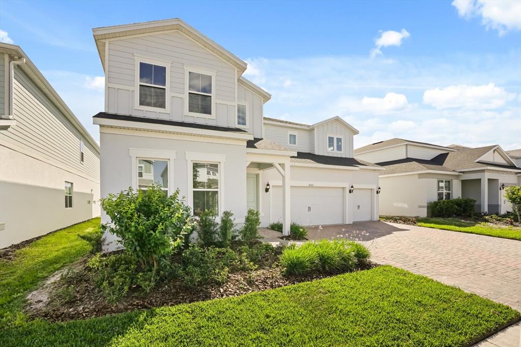 A two-story house with light gray siding, a paved driveway, and a two-car garage — 8352 PARK CLIFF WAY, ORLANDO, FL