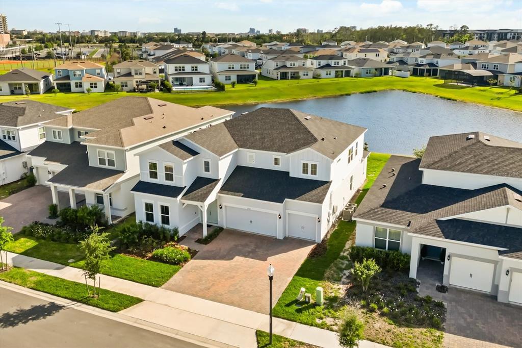 An aerial view shows a two-story suburban house with a brick driveway and pond — 8352 PARK CLIFF WAY, ORLANDO, FL
