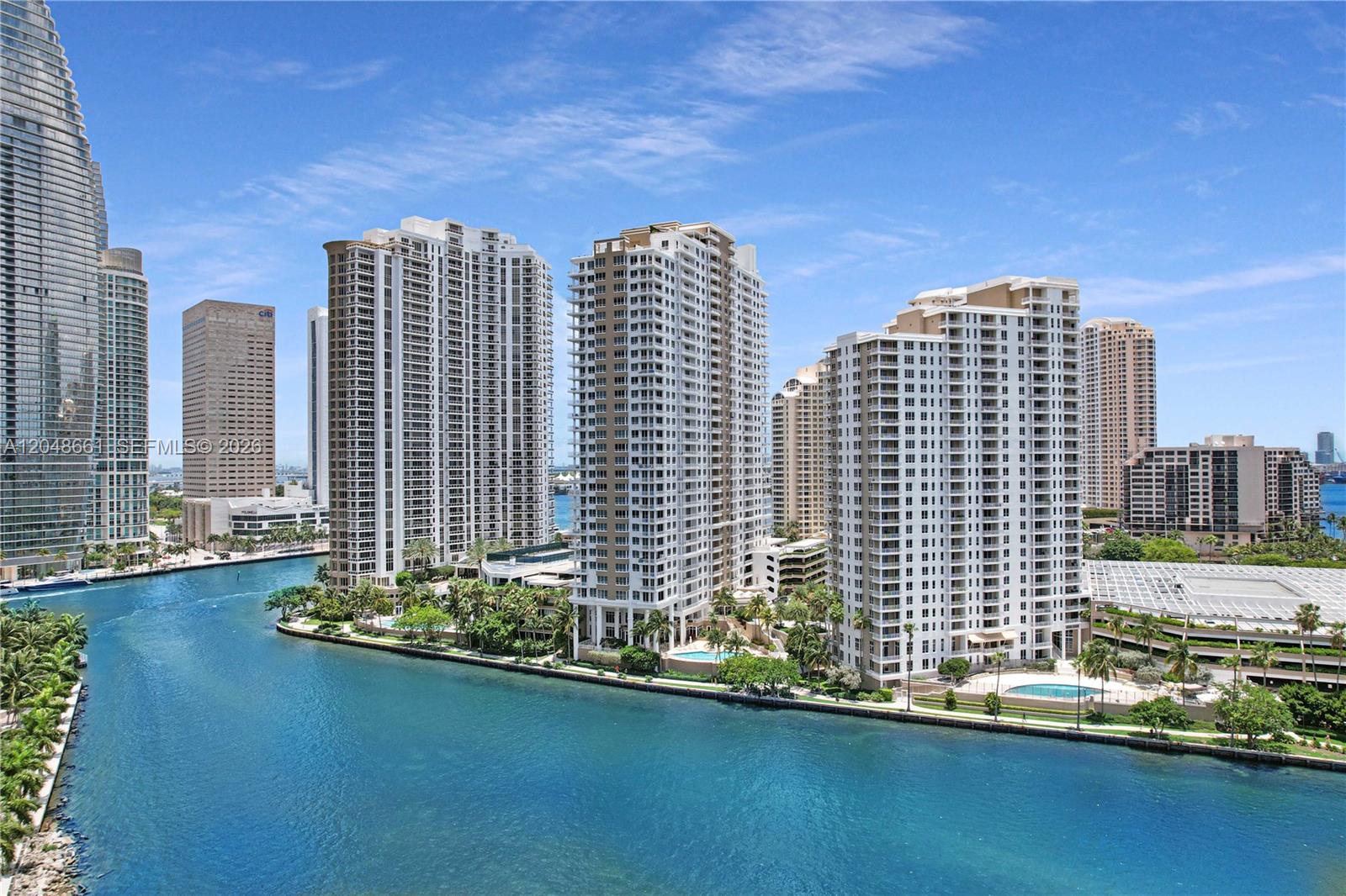 An aerial view shows several high-rise residential buildings situated along a blue waterway — 801 Brickell Key Blvd # 2210, Miami FL 33131, MIAMI, FL