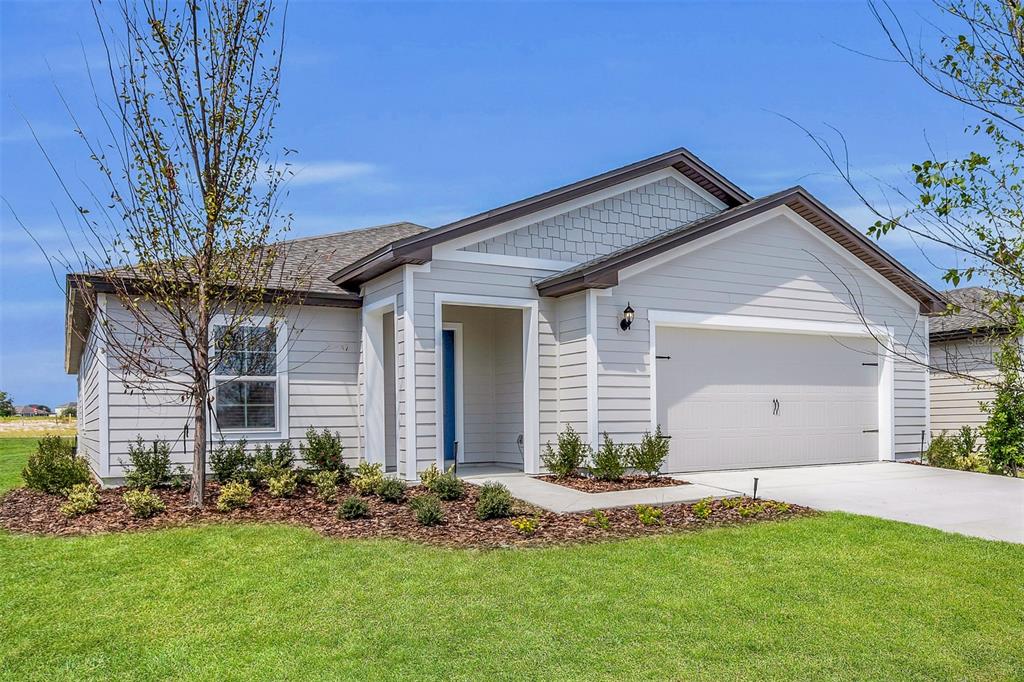 A single-story house with light gray siding, a two-car garage, and a blue front door — 2517 SW 165TH STREET ROAD, OCALA, FL