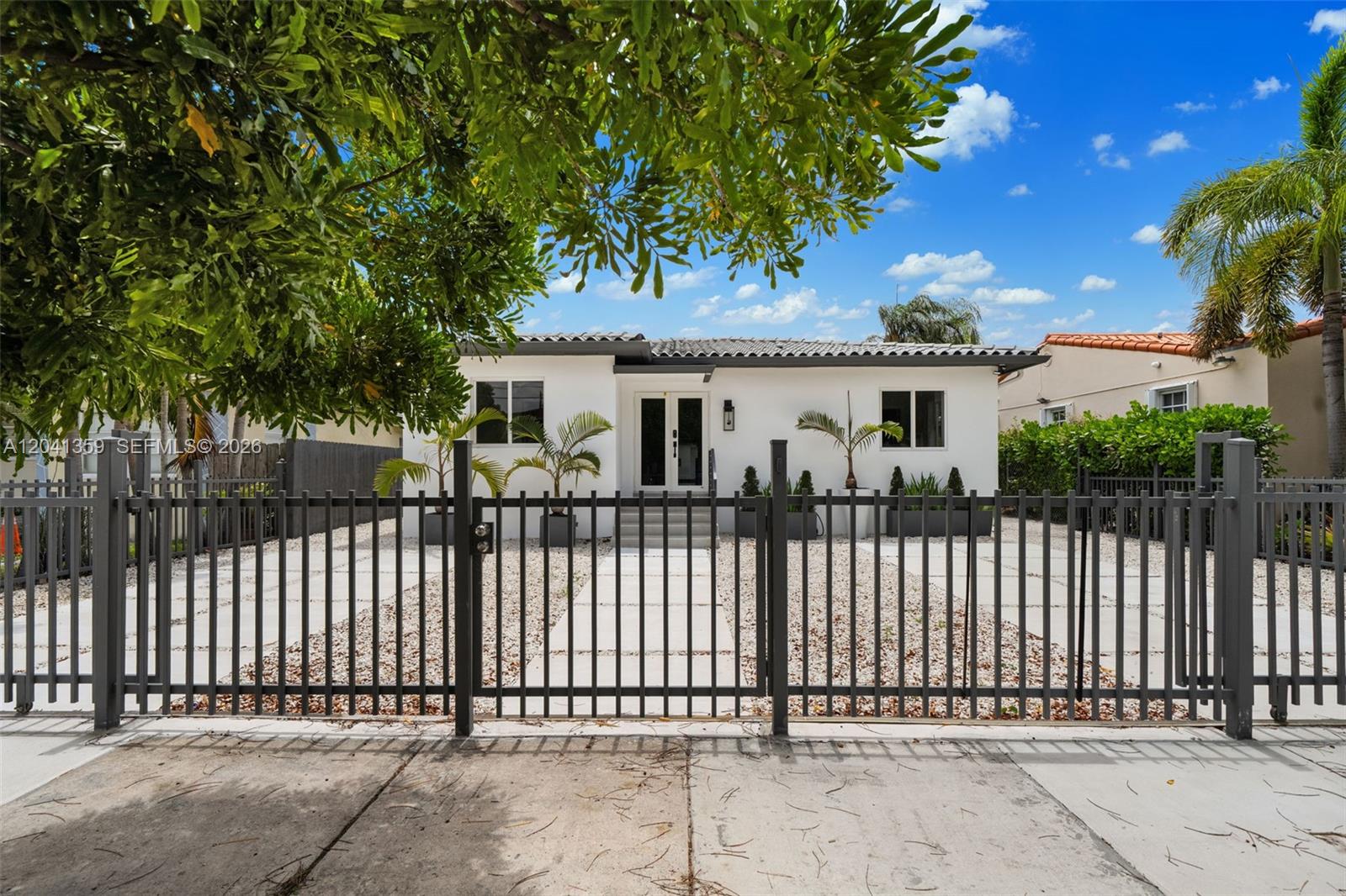 A white single-story house with a dark metal fence and gravel front yard — 2940 SW 12th St, Miami FL 33135, MIAMI, FL
