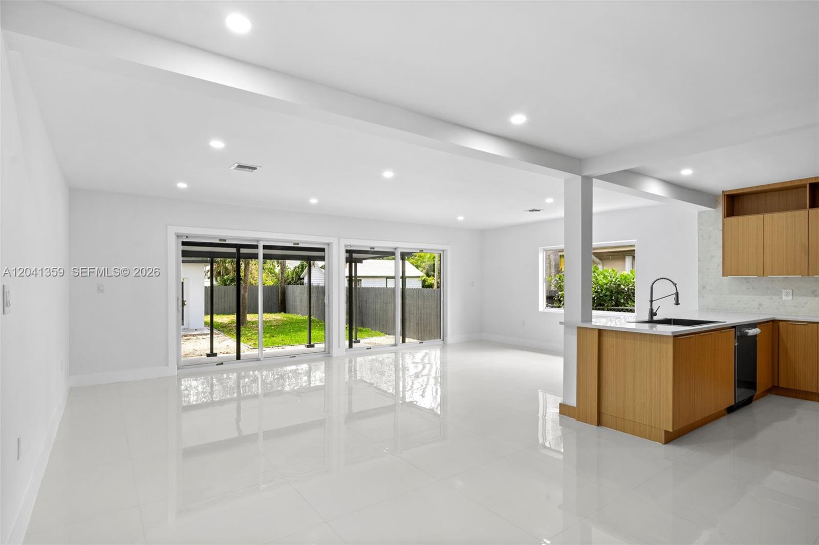 A bright, open-concept living area features white tile floors, recessed lighting, and a modern kitchen — 2940 SW 12th St, Miami FL 33135, MIAMI, FL
