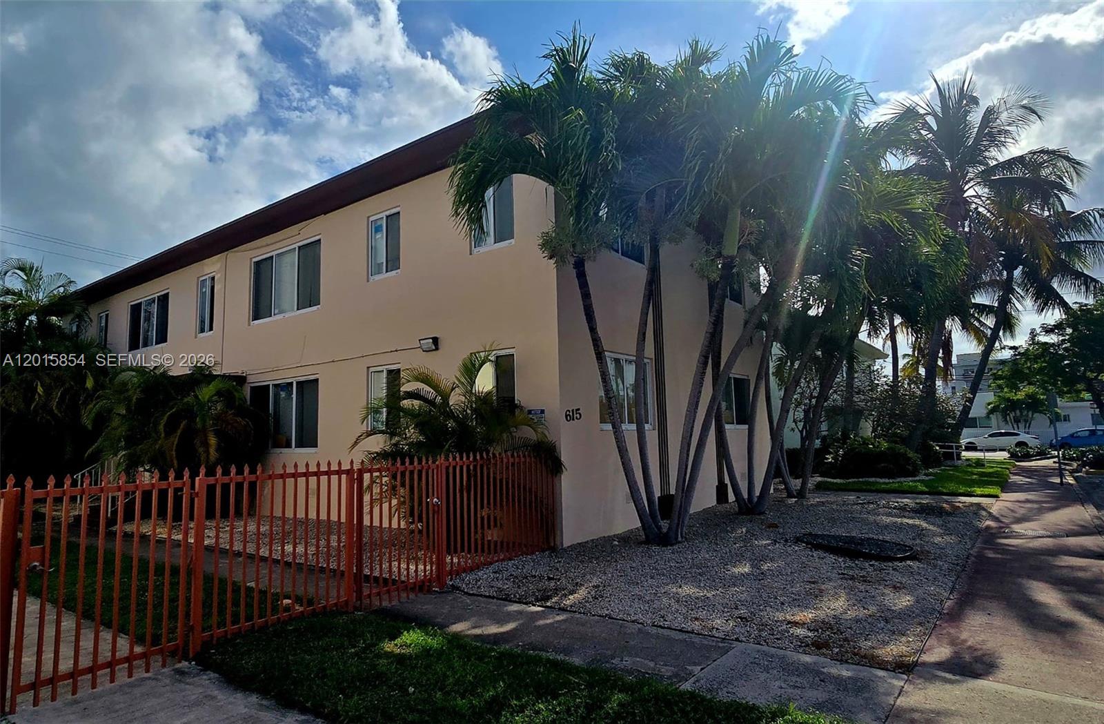 A two-story apartment building with beige stucco walls and palm trees in the front yard — 615 82nd St # 1, Miami Beach FL 33141, MIAMI BEACH, FL