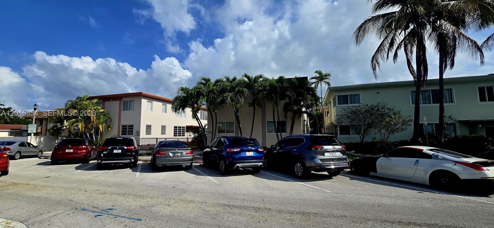 A parking lot sits in front of two multi-story apartment buildings under a cloudy sky — 615 82nd St # 1, Miami Beach FL 33141, MIAMI BEACH, FL