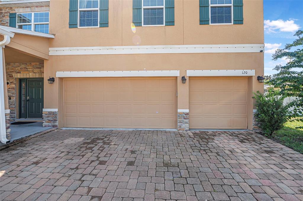 A tan two-story house with a three-car garage and a paved driveway — 120 LOS ARBOR DRIVE, DELAND, FL