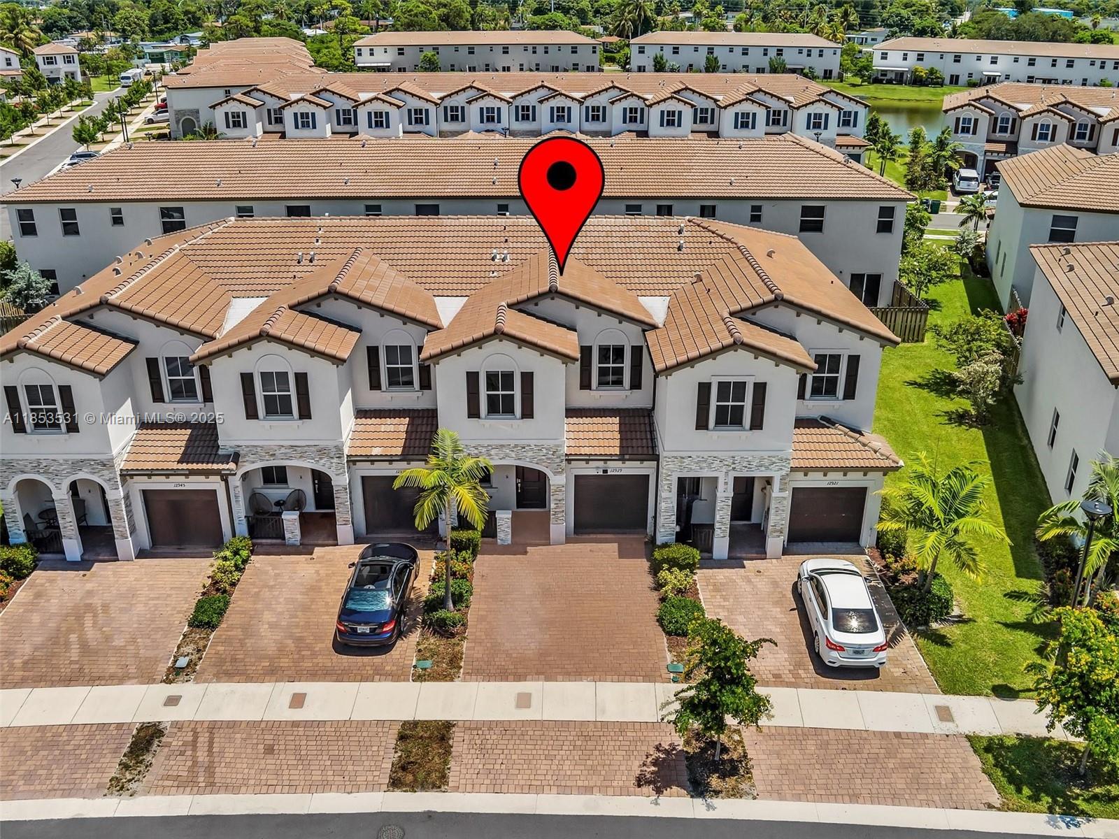 An aerial view shows a row of two-story townhouses with brown tile roofs and driveways — 12929 NW 24th Ave, Miami FL 33167, MIAMI, FL