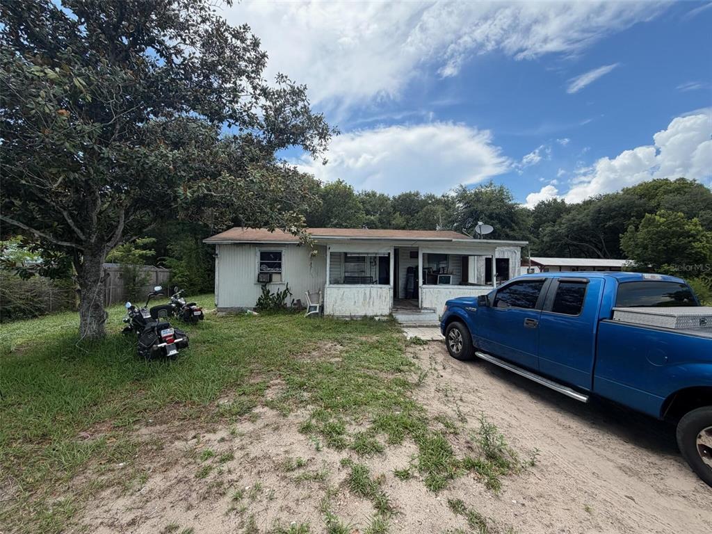 A single-story house with a screened porch and a blue pickup truck parked in front — 1724 S US 301, SUMTERVILLE, FL