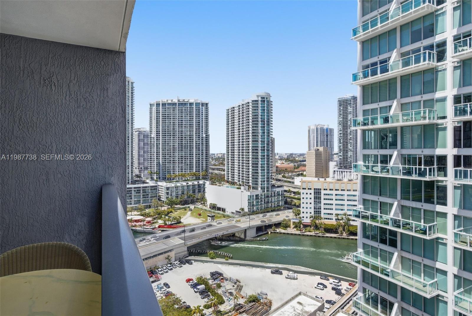 A high-angle view from a balcony overlooking a city skyline, a river, and a parking lot — 31 SE 6th St # 2504, Miami FL 33131, MIAMI, FL