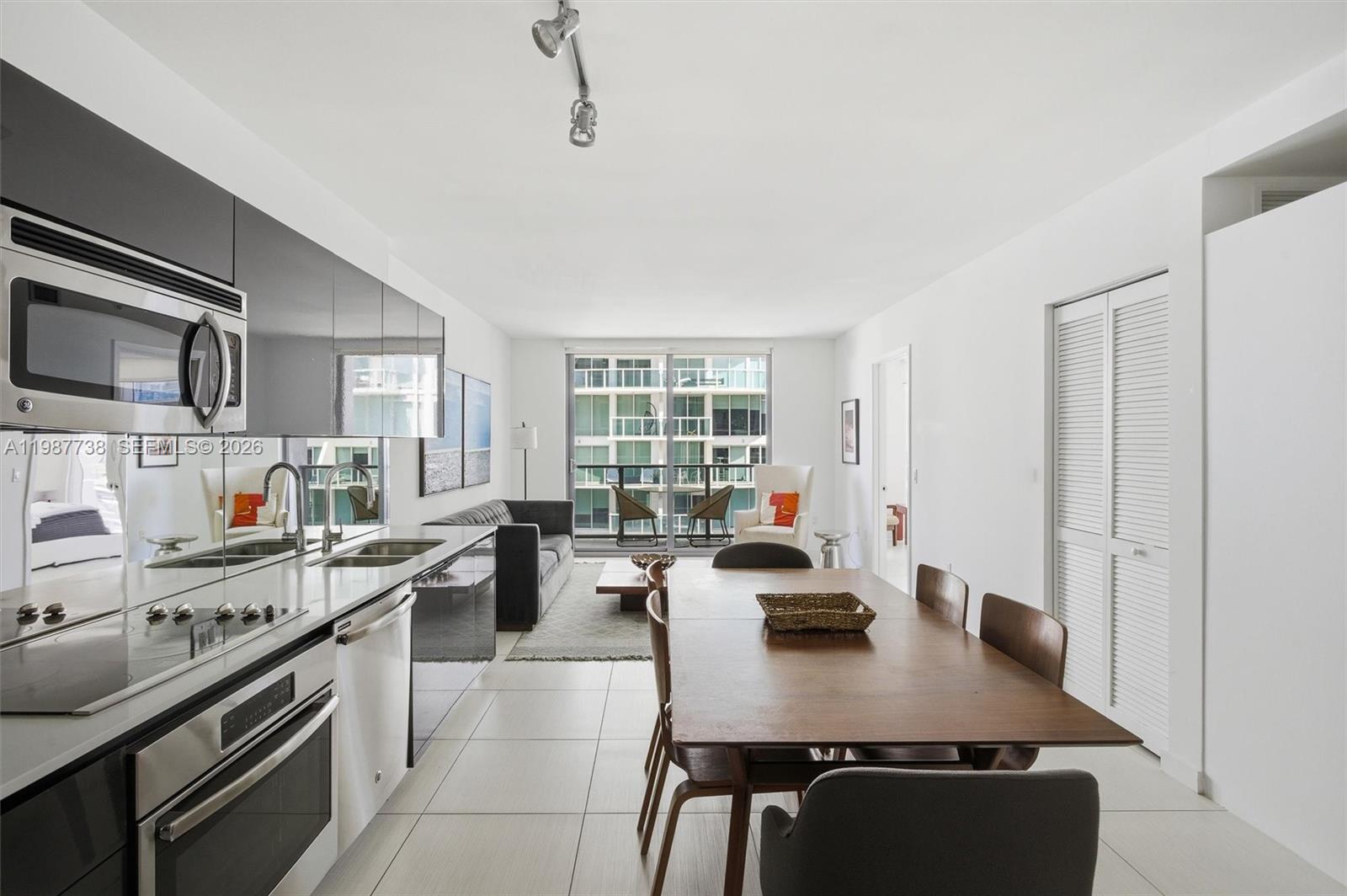A modern open-concept kitchen, dining area, and living room with white tile flooring — 31 SE 6th St # 2504, Miami FL 33131, MIAMI, FL