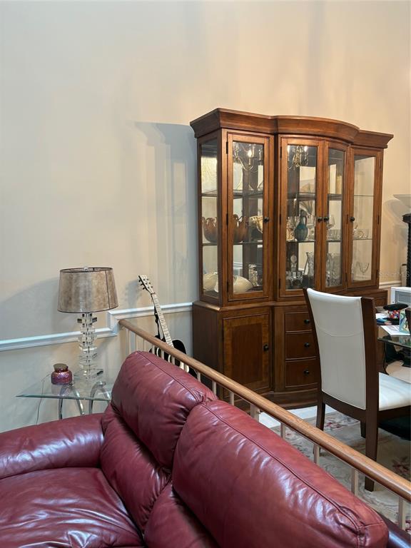 A living room features a red leather sofa, a glass side table, and a wooden hutch — 2336 SUN VALLEY CIRCLE BLDG 20, WINTER PARK, FL