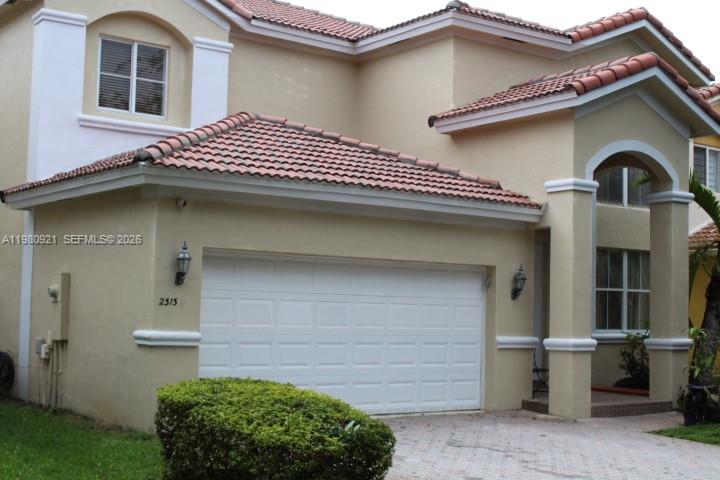 A two-story house with a tan stucco exterior, a white garage door, and a tiled roof — 2313 SW 126th Ave, Miramar FL 33027, MIRAMAR, FL