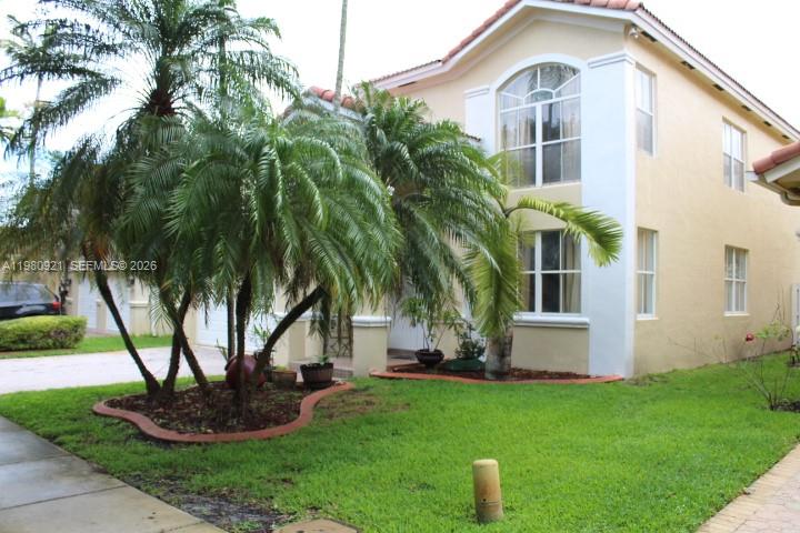 A two-story beige house with a tiled roof and palm trees in the front yard — 2313 SW 126th Ave, Miramar FL 33027, MIRAMAR, FL
