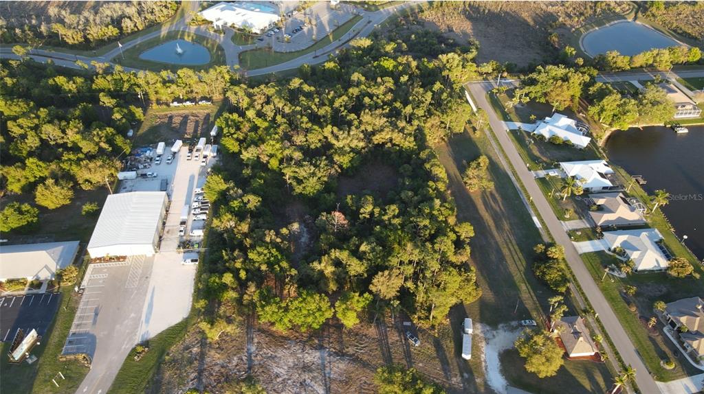Aerial view of a wooded lot situated between a commercial building and residential houses — 12354 SW CO ROAD 769, LAKE SUZY, FL