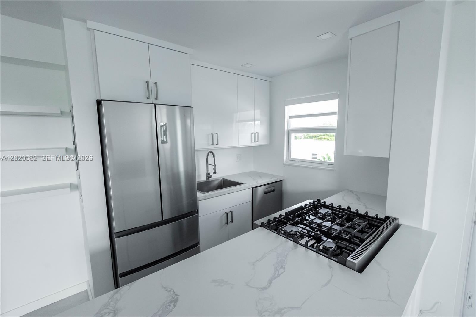 A modern kitchen features white cabinets, stainless steel appliances, and a marble-patterned countertop — 301 Jefferson Ave # 4E, Miami Beach FL 33139, MIAMI BEACH, FL