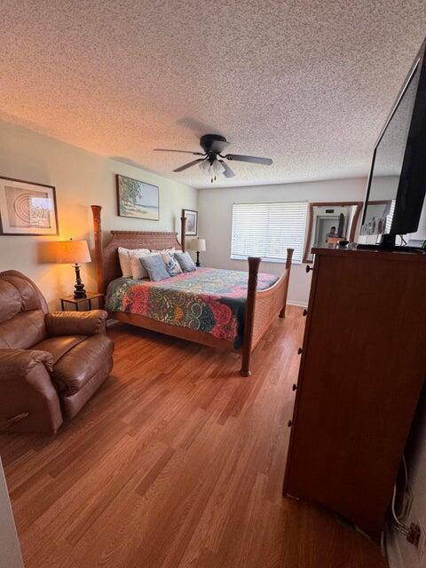 A bedroom features a wooden bed frame, a leather recliner, and wood-look flooring — 353 S Us Highway 1 # A407, Jupiter FL 33477, JUPITER, FL