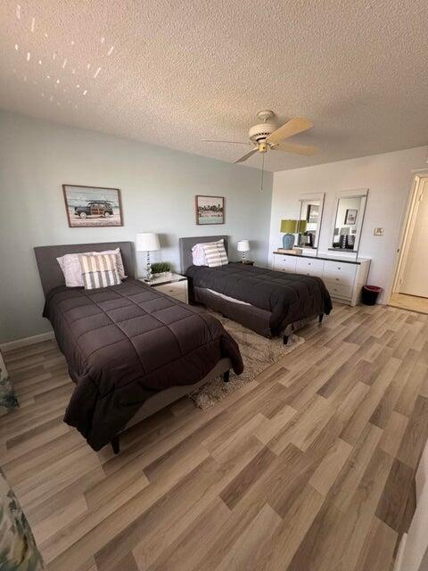 A bedroom features two twin beds, light blue walls, and wood-look flooring — 353 S Us Highway 1 # A407, Jupiter FL 33477, JUPITER, FL