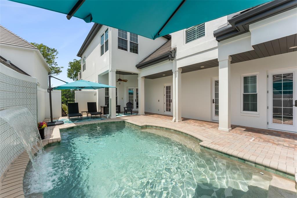 A backyard features a swimming pool with a water feature and a covered patio area — 9720 COVENT GARDEN DRIVE, ORLANDO, FL