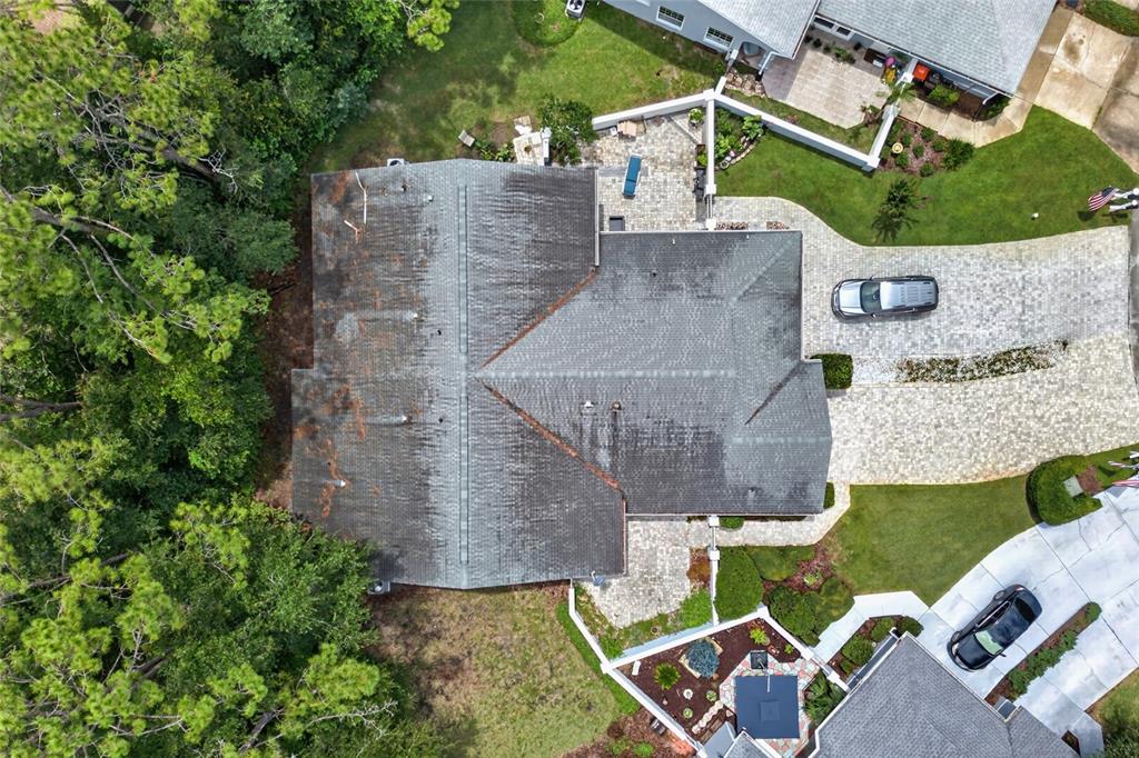 An aerial view shows a house with a dark shingled roof, paved driveway, and landscaping — 8055 SW 115TH LOOP, OCALA, FL
