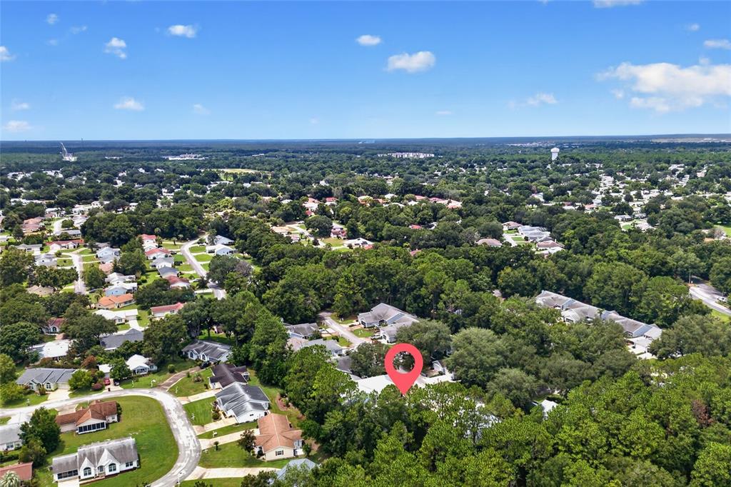 An aerial view shows a suburban neighborhood with a red pin marking a specific house — 8055 SW 115TH LOOP, OCALA, FL