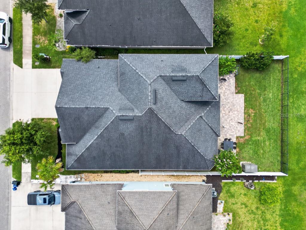 An aerial view shows the roof of a house with a paved patio and backyard — 161 S COOPERS HAWK WAY, PALM COAST, FL