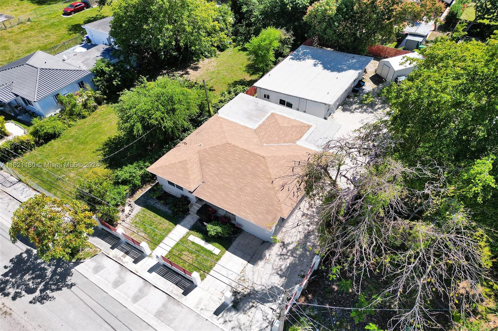 An aerial view shows a house with a brown roof, a detached garage, and landscaping — 418 NW 47th St, Miami FL 33127, MIAMI, FL