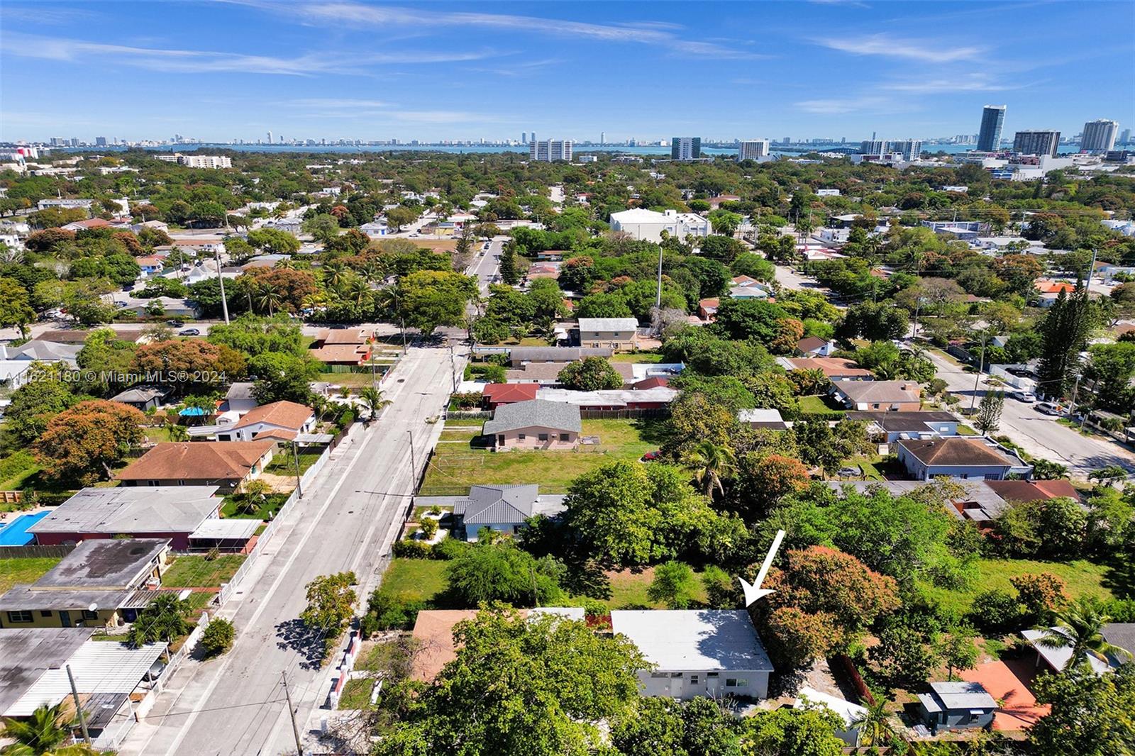 An aerial view shows a residential neighborhood with a white-roofed house marked by an arrow — 418 NW 47th St, Miami FL 33127, MIAMI, FL