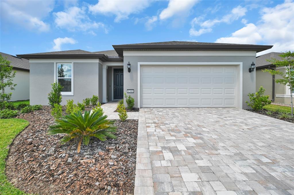 A single-story house with a gray exterior, a two-car garage, and a paved driveway — 8348 SW 58TH LOOP, OCALA, FL