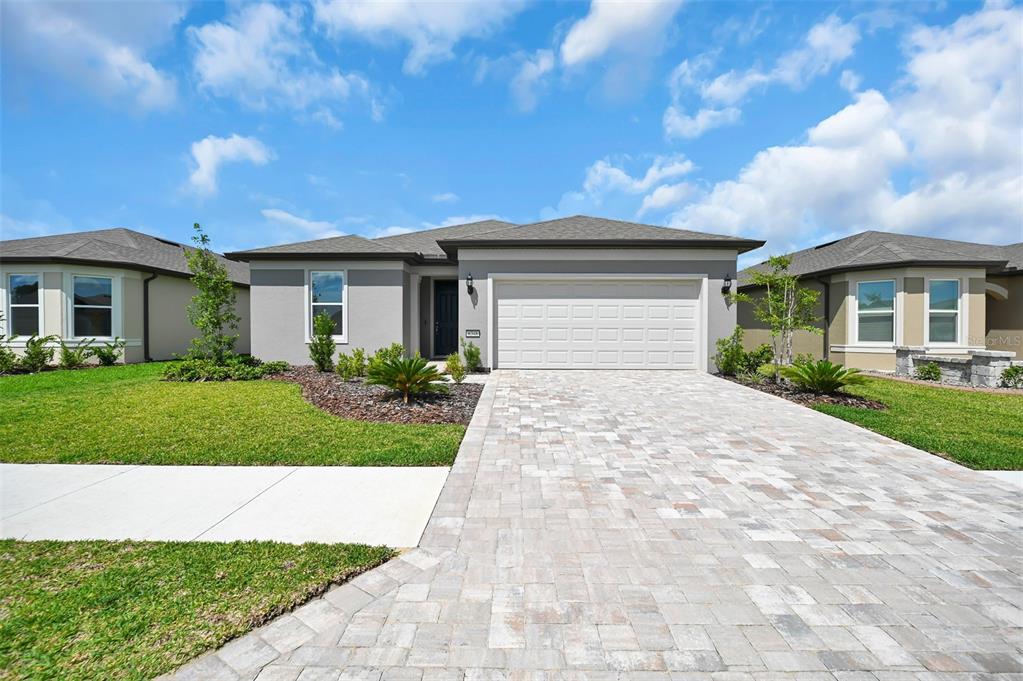 A single-story house with a gray exterior, a two-car garage, and a paved driveway — 8348 SW 58TH LOOP, OCALA, FL