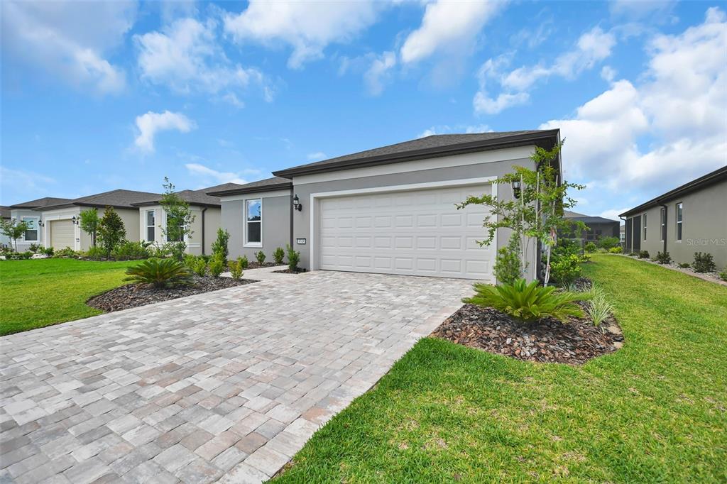 A gray single-story house with a two-car garage and a paved driveway — 8348 SW 58TH LOOP, OCALA, FL