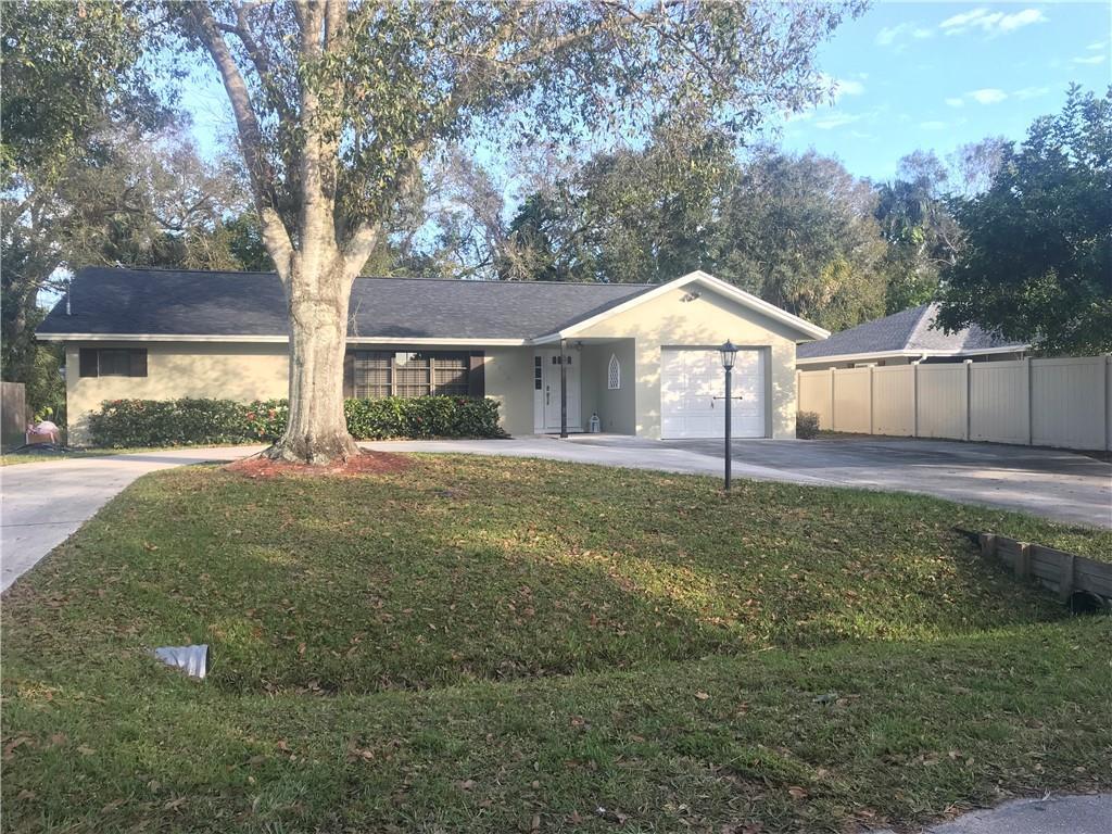A single-story house with a light-colored exterior, a garage, and a large tree in front — 2536 44th Avenue, Vero Beach FL 32966, VERO BEACH, FL