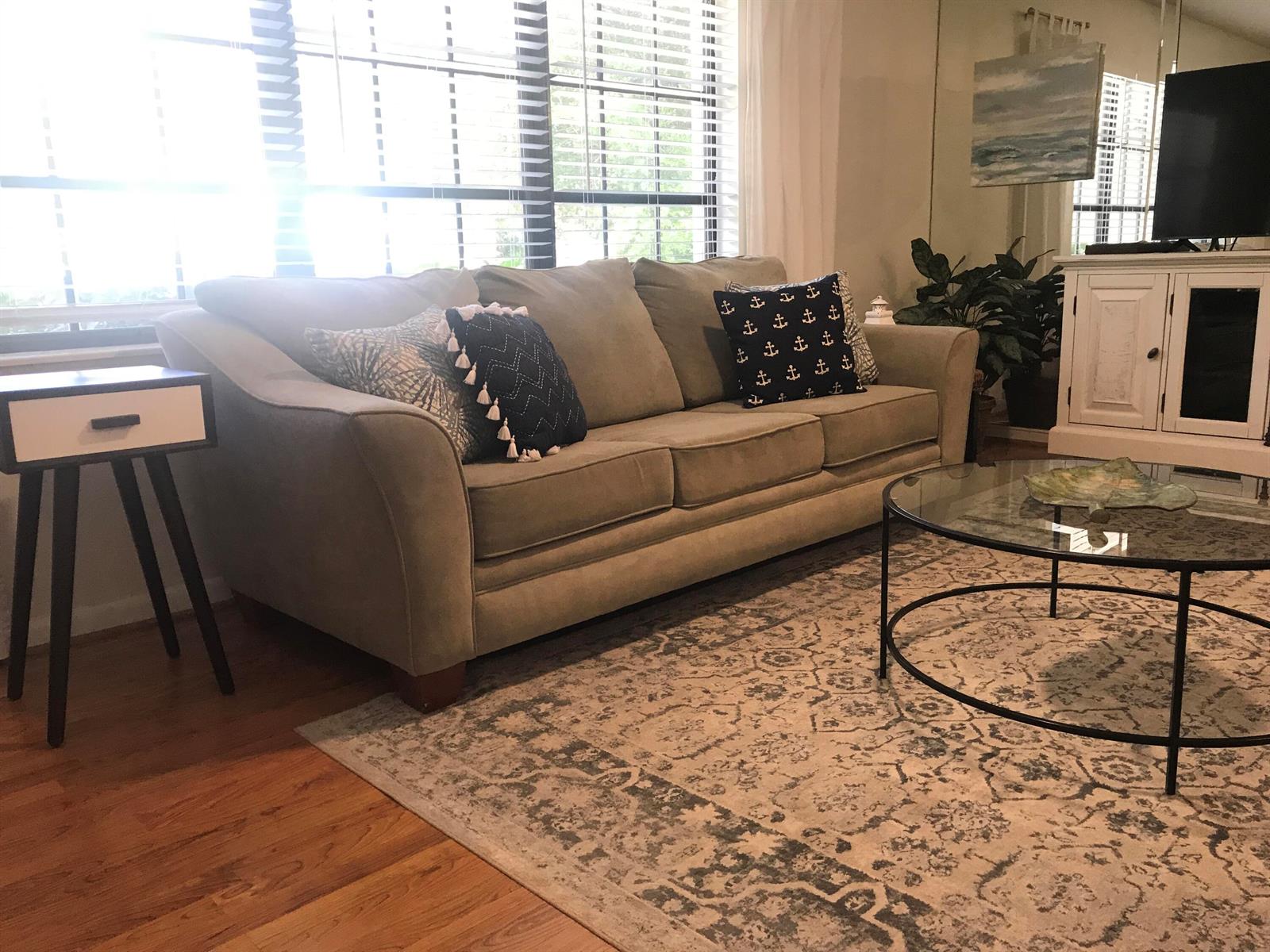 A living room features a beige sofa, a glass coffee table, and a patterned area rug — 2536 44th Avenue, Vero Beach FL 32966, VERO BEACH, FL