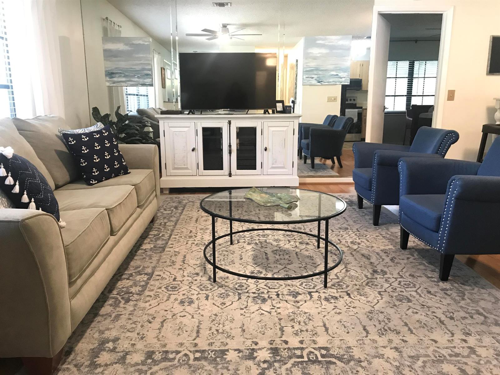 A living room features a beige sofa, two blue armchairs, and a glass coffee table — 2536 44th Avenue, Vero Beach FL 32966, VERO BEACH, FL