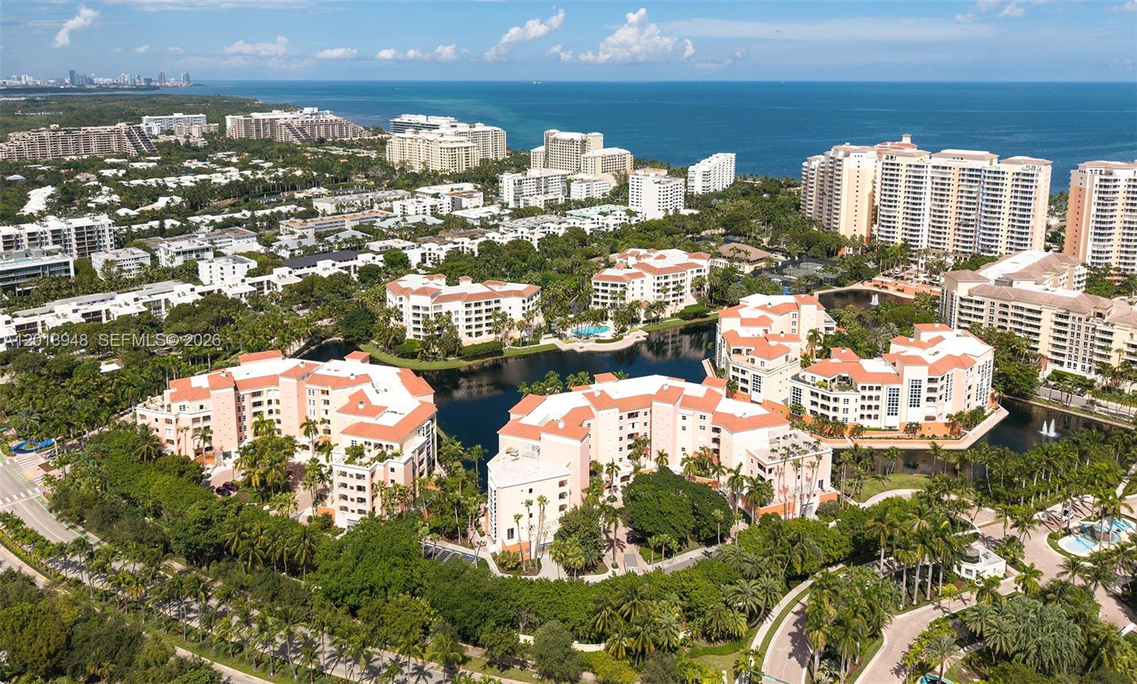 An aerial view shows multi-story residential buildings surrounding a central lake near the ocean — 733 Crandon Blvd # 406, Key Biscayne FL 33149, KEY BISCAYNE, FL