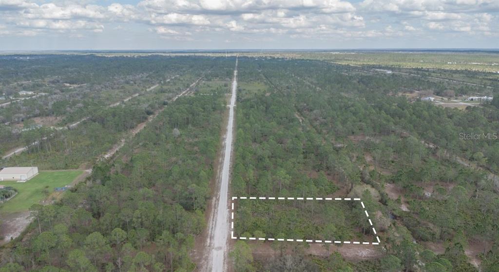 An aerial view shows a rectangular plot of land outlined in white along a dirt road — 13 ALBA DRIVE, INDIAN LAKE ESTATES, FL