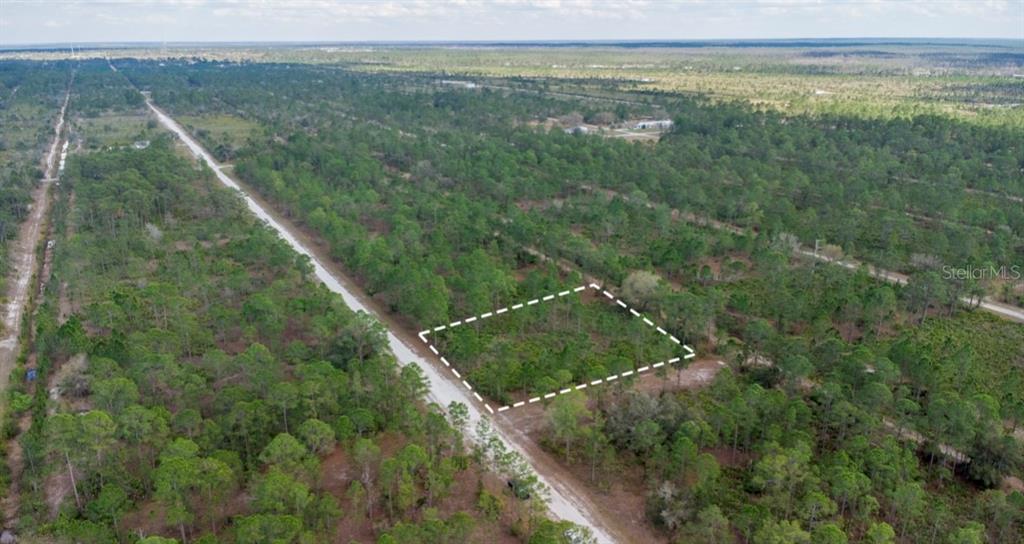 An aerial view shows a rectangular plot of land outlined in white along a dirt road — 13 ALBA DRIVE, INDIAN LAKE ESTATES, FL