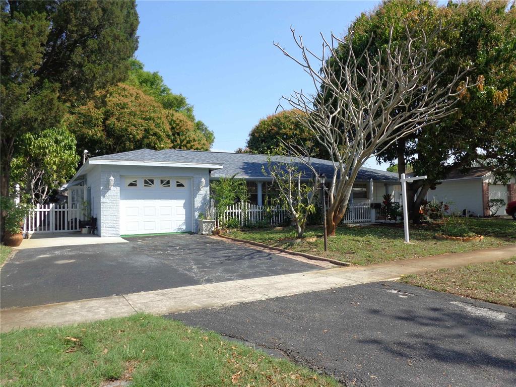 A covered porch features white columns, tile flooring, and a white picket fence — 6165 26TH AVENUE N, ST PETERSBURG, FL