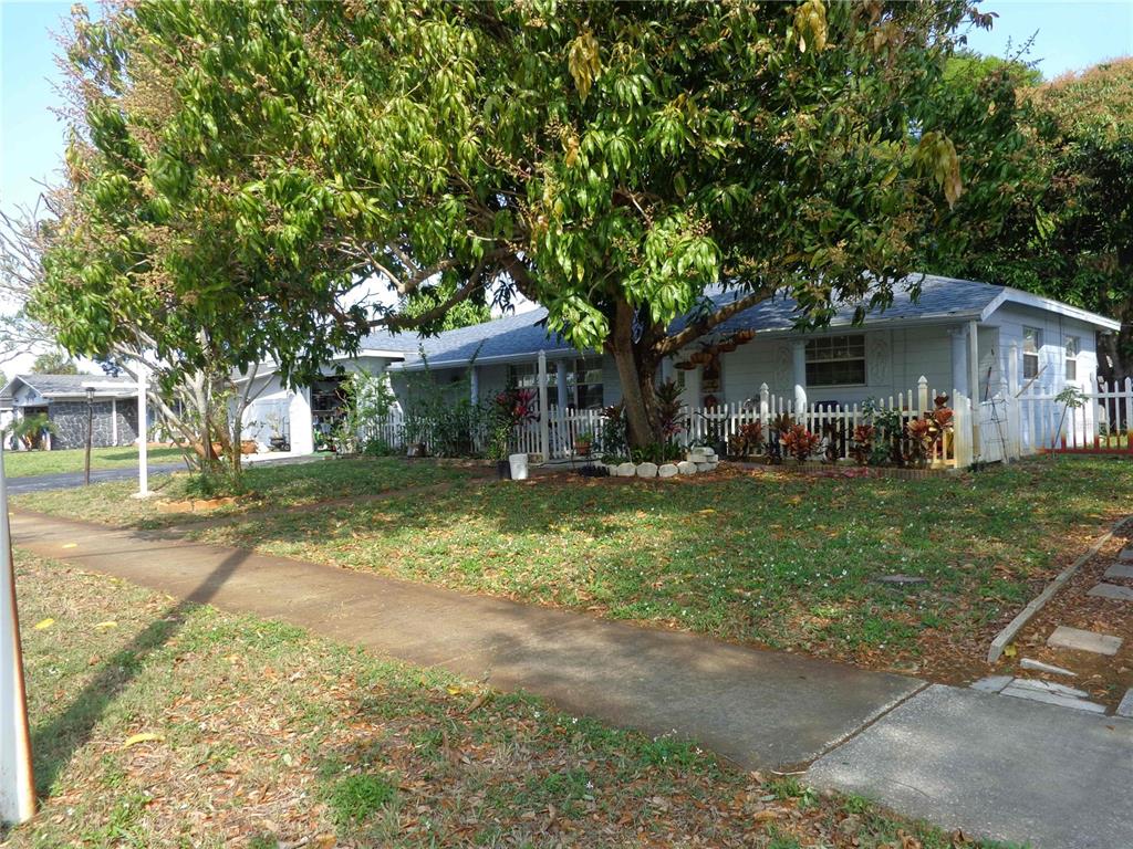 A covered front porch features white columns, a tiled floor, and a white picket fence — 6165 26TH AVENUE N, ST PETERSBURG, FL