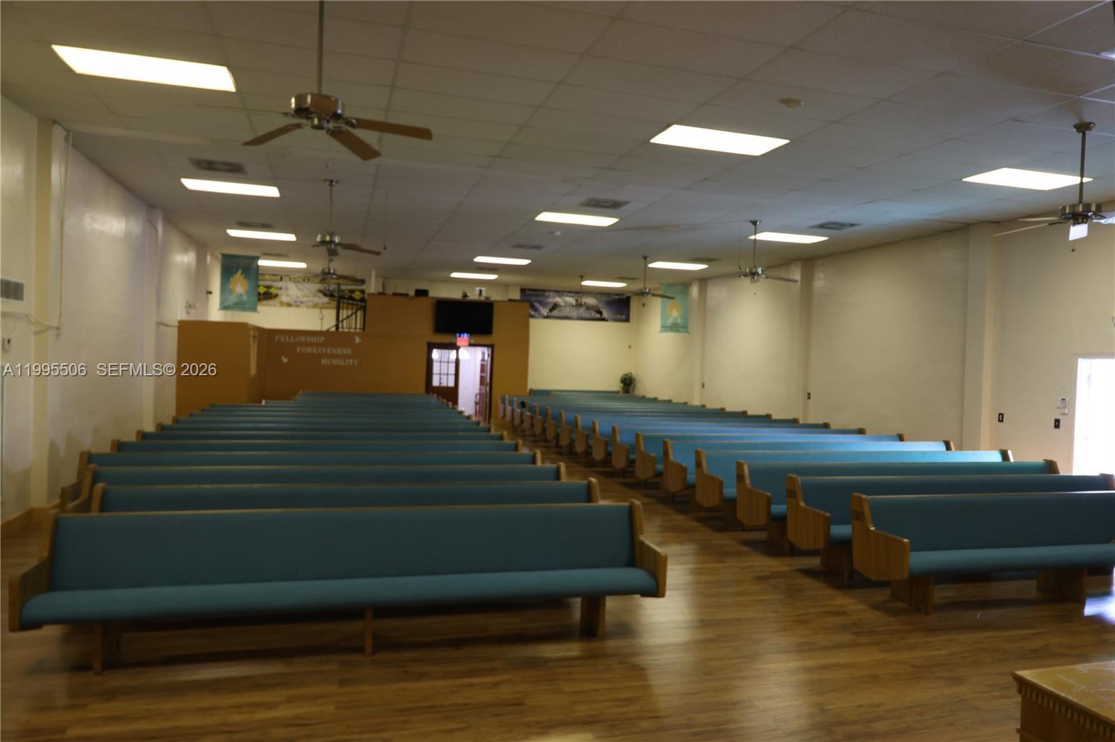 A large church sanctuary features rows of blue pews on a wood floor — 4343 NW 17th Ave, Miami FL 33142, MIAMI, FL