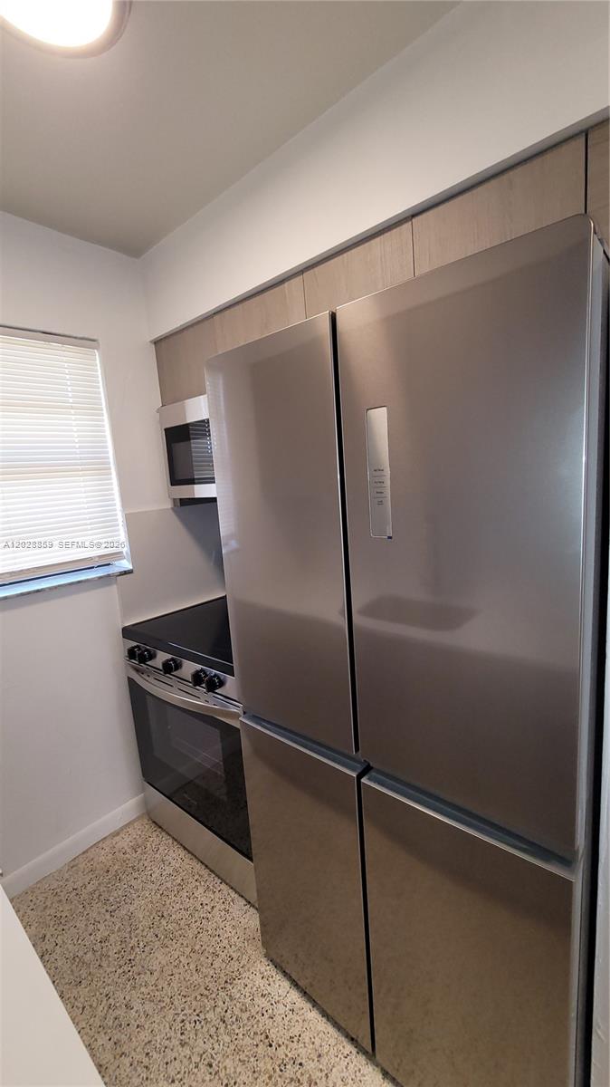 A kitchen features stainless steel appliances, light wood cabinetry, and a speckled floor — 34 E 21st St # 3, Hialeah FL 33010, HIALEAH, FL