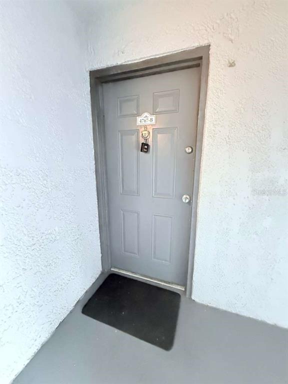 A gray entry door with a lockbox and unit number 4767-B sits in a stucco alcove — 4767 S TEXAS AVENUE UNIT 4767B, ORLANDO, FL