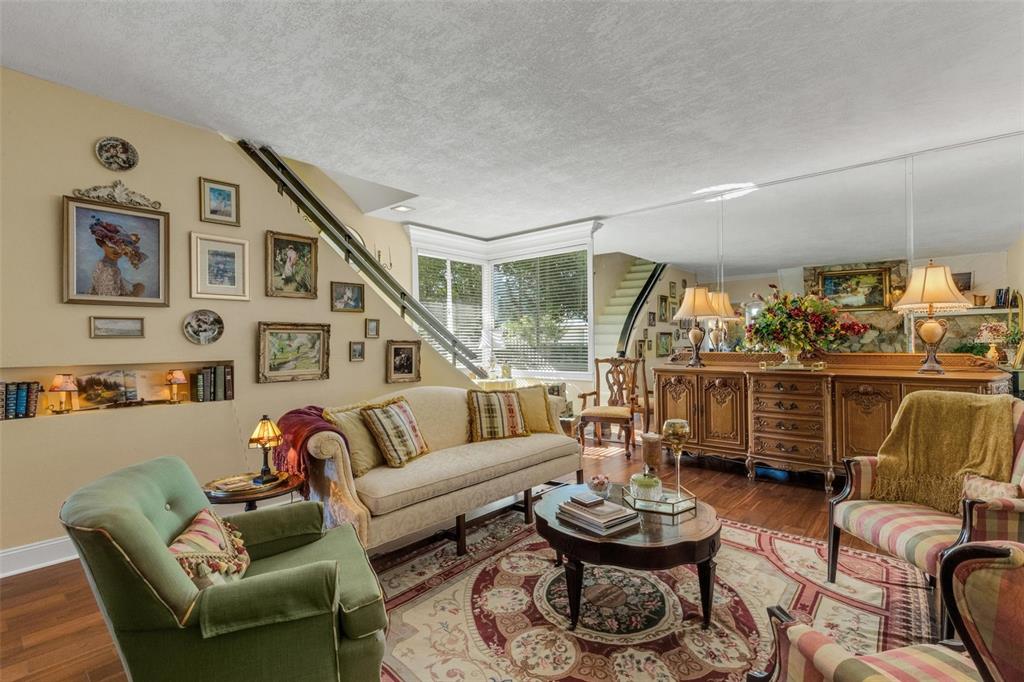 A living room features a staircase, a gallery wall, a patterned rug, and wooden furniture — 2015 E BEACON BY WAY, LAKELAND, FL