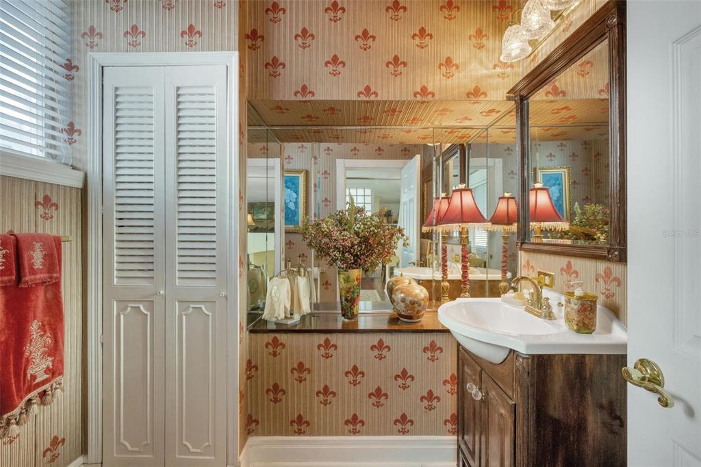 A bathroom features fleur-de-lis wallpaper, a vanity with a vessel sink, and mirrored walls — 2015 E BEACON BY WAY, LAKELAND, FL