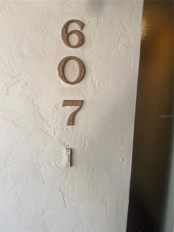 The number 607 is mounted on a textured white wall above a doorbell button — 607 COUNTRY LANE NE UNIT 607, WINTER HAVEN, FL
