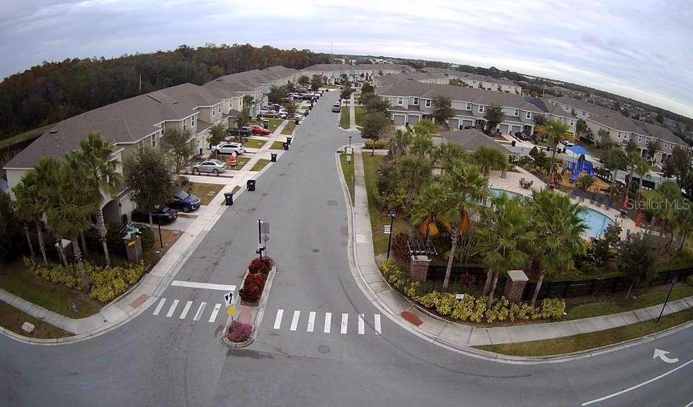 An aerial view shows a residential street with townhomes, a community pool, and a playground — 10731 SILK TREE COURT, ORLANDO, FL