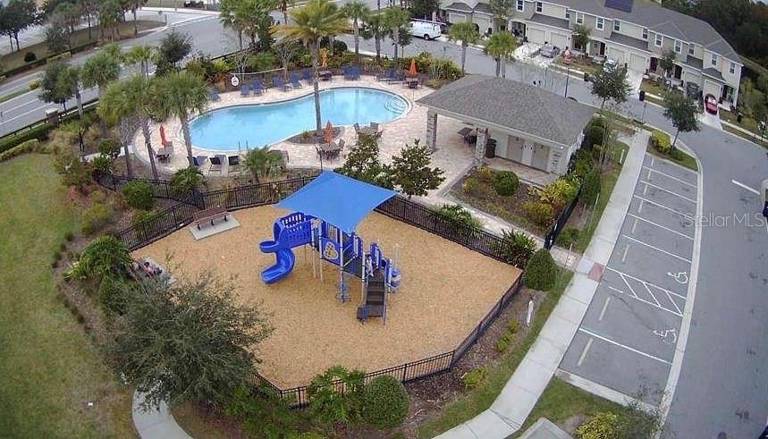 An aerial view shows a fenced playground, a swimming pool, and a community building — 10731 SILK TREE COURT, ORLANDO, FL