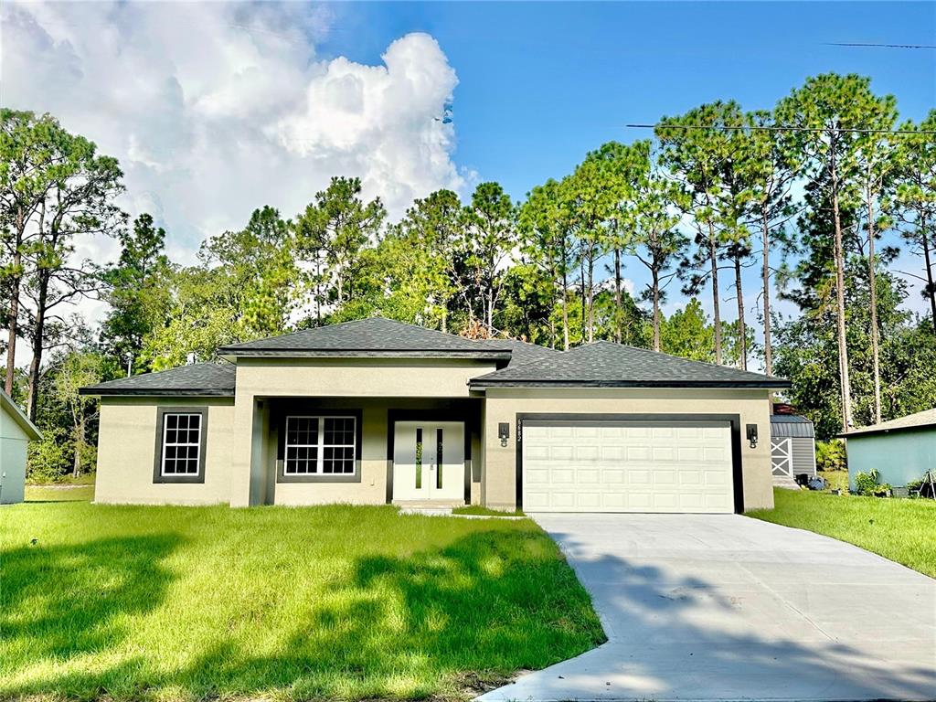 A single-story house with a beige exterior, a two-car garage, and a large front lawn — 6682 N EDELWEISS WAY, CITRUS SPRINGS, FL