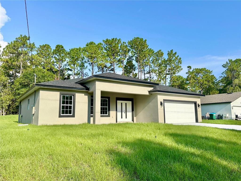 A single-story house with a beige stucco exterior, dark trim, and an attached two-car garage — 6682 N EDELWEISS WAY, CITRUS SPRINGS, FL