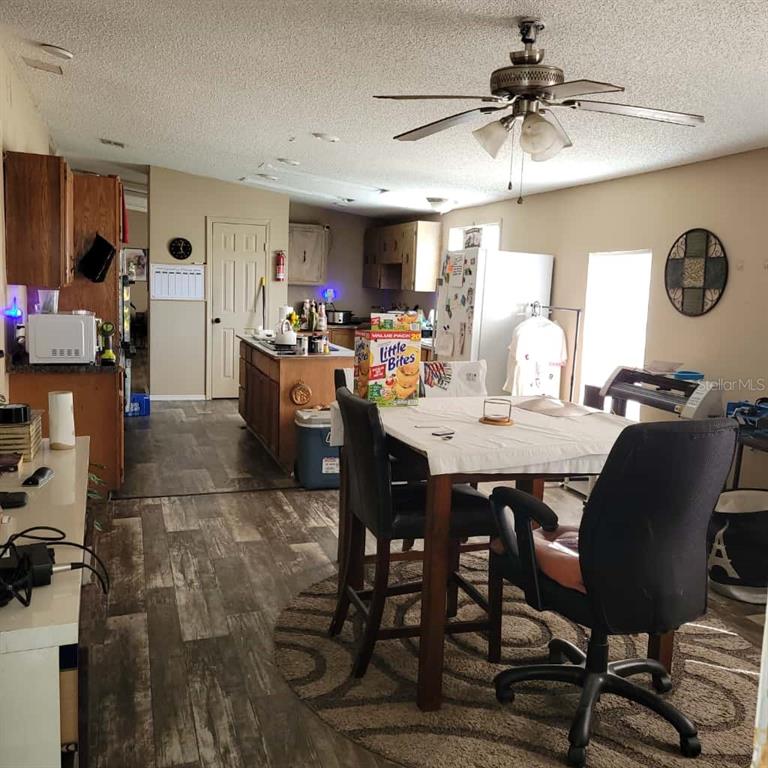 A kitchen and dining area features wood-look flooring, a ceiling fan, and a center island — 16165 NARROW STREET, BROOKSVILLE, FL